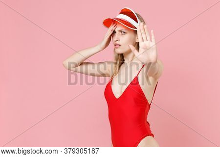 Tired Young Blonde Woman In Red One-piece Swimsuit Cap Isolated On Pink Background. People Summer Va