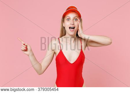 Shocked Young Blonde Girl In Red One-piece Swimsuit Cap Isolated On Pink Background. People Summer V