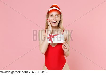 Excited Young Blonde Woman In Red One-piece Swimsuit Cap Posing Isolated On Pink Background. People 