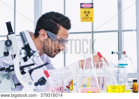 Doctor And Microbiologist With Vacuum Tubes For Samples With Covid 19 Infection Atypical Pneumonia V