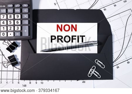 Non Profit. Text On White Paper On Black Envelope Over The Financial Graphics And The Calculator Vie