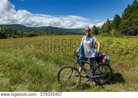 Vedenshina, Irkutskaya Oblast, Russia - July 30 2020: A Woman With A Mountain Bicycle Smiling In A W