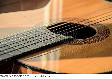 Close-up Of Guitar Strings In Sunlight. Guitar Fretboard Part, Acoustic Six-string Wooden Guitar, St