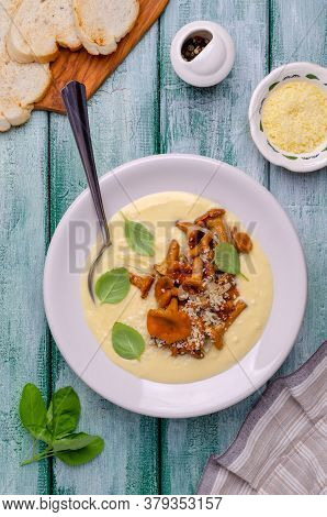 Traditional Polenta With Mushrooms And Cheese In A Dish On A Green Wooden Background. Selective Focu