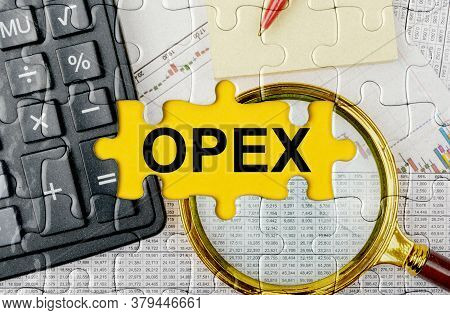 Business Concept. Puzzle With A Calculator, Magnifying Glasses And Financial Documents In The Center
