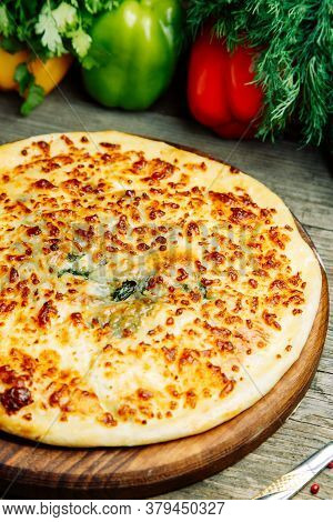 Khachapuri In Megrelian On The Board. Azerbaijani Restaurant Dish With Vegetable Decor On A Wooden B