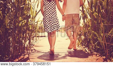 Brother and sister walking on the dock of the lake