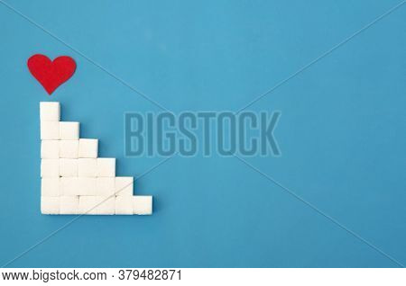 Ladder Of Sugar Cubes Laid Out, A Red Heart At The Top Of The Stairs On A Blue Background, Copy Spac