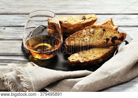 Italian Biscotti Cookies On Black Slate Board And Sweet Wine Vin Santo. Fresh Baked Cookies With Nut