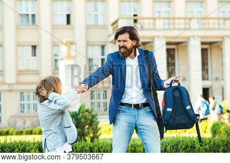 Schoolboy Does Not Want To Go To School. Father Taking Son To School. Dad Hurries, Is Late To School