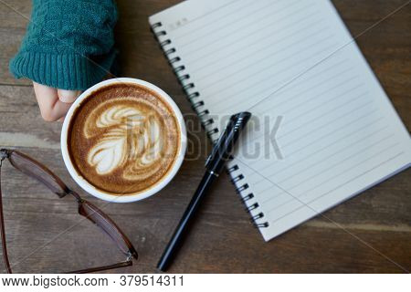 Hot Healthy And Tasty Coffie Drink On The Cup With Notebook