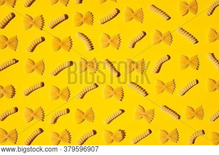 Uncooked Curly Pasta Pattern On Yellow Background. Traditional Dry Raw Macaroni Pattern. Nobody