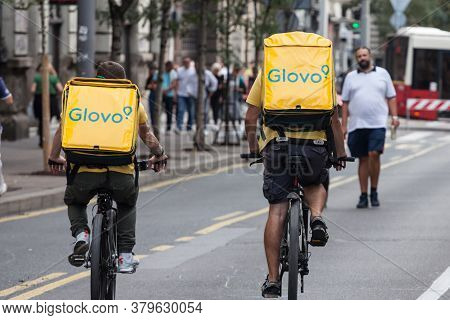 Belgrade, Serbia - September 28, 2019: Glovo Logo On The Bag Of Two Delivery Men On Their Bicycles I