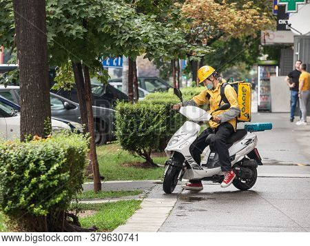 Belgrade, Serbia - July 26, 2020: Glovo Delivery Man Wearing A Face Mask Protective Respirator In Be