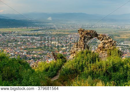 Ruins Of Old Hungarian Castle With A City View At Sunset, Khust, Western Ukraine.