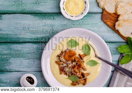 Traditional Polenta With Mushrooms And Cheese In A Dish On A Green Wooden Background. Selective Focu