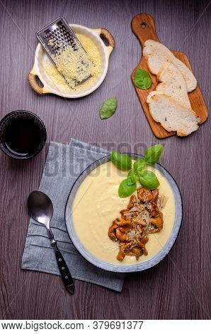Traditional Polenta With Mushrooms And Cheese In A Dish On A Dark Wooden Background. Selective Focus