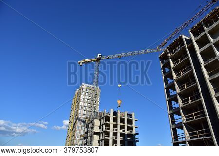 Preparing To Pour A Bucket Of Concrete Into Formwork.tower Crane Lifting Cement Bucket During Constr