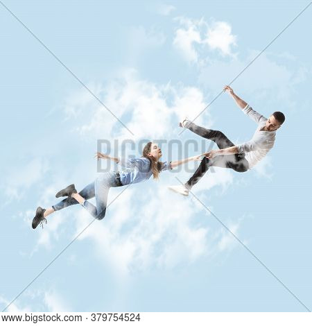 Mid-air Beauty Cought In Sky. Full Length Shot Of Attractive Young Woman And Man Hovering In Air And