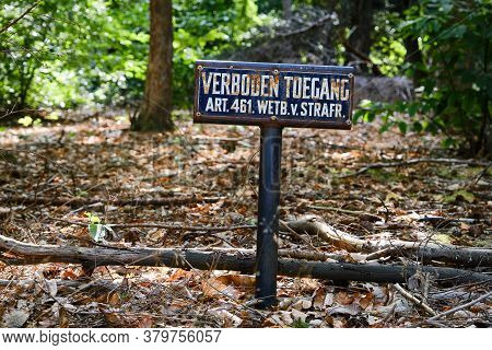 Dutch Old Blue Rusty Prohibited Access Sign In A Wooded Area. Criminal Code Act.461, Art.461. Englis