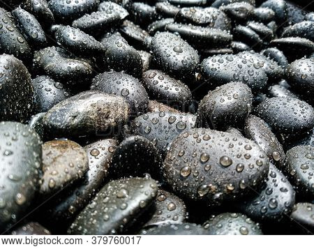 Many Dark Stones Of Various Sizes Covered With Small Drops Of Water, Sprayed With Water. Black, Gray