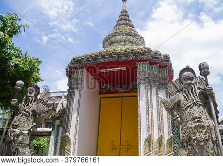 Two Chinese Stone Guardian Statues At Wat Pho Buddhist Temple Complex Door In Bangkok, Thailand