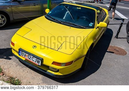 Brasov, Romania- 06 August 2020: Vibrant Yellow Toyota Celica Sport Car In Good Condition On The Par