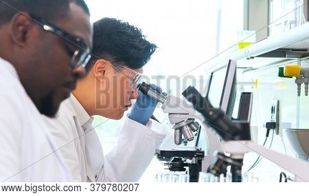 Scientist and students working in lab. Doctor teaching interns to make analyzing research. Biotechnology, chemistry, bacteriology, virology, dna and health care concept.