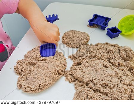 Child Plays With Kinetic Sand: Closeup Of A Child's Hand And Sand. Educational Games With Children F