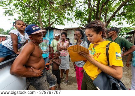 San Cristobal / Dominican Republic - May 16 2018: Brown Woman Signs Some Papers In Front Of A Shirtl