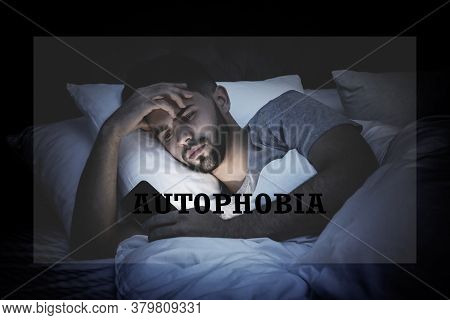 Depressed Young Man With Smartphone In Bed At Night. Autophobia - Fear Of Isolation