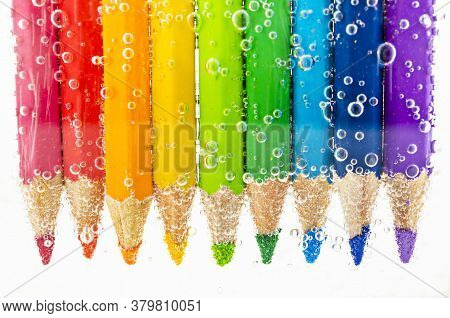 Colorful Pencils In Water With Bubbles On White Background