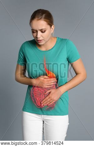 Woman Suffering From Stomach Pain On Grey Background