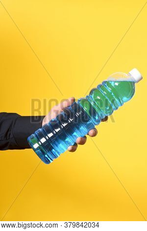 Hand With Detergent Bottle On Yellow Background