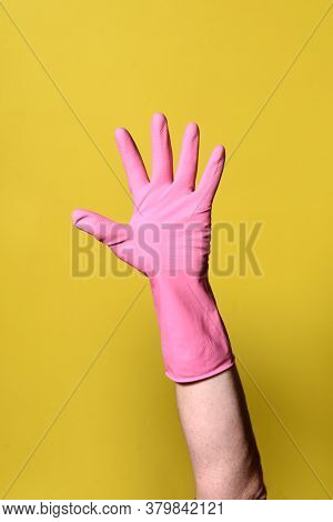 Hand With Glove On A Yellow Background