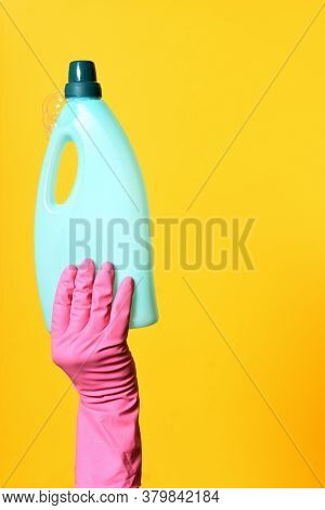 A Hand With Gloves Holding Soap Bottle