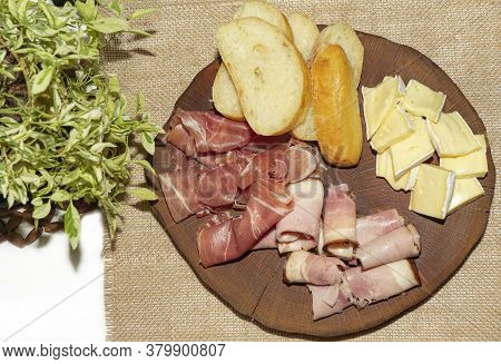 Wine Appetizer. Ham, Parma Ham, Baguette, Cheese On A Wooden Stand. Board For Appetizers-cheese, Ham
