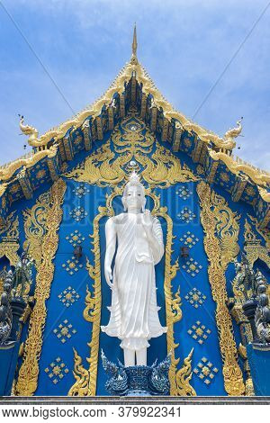 Chiangrai, Thailand - June 7, 2020: Standing White Buddha On Yellow Blue Wat Rong Suea Ten Church Ba