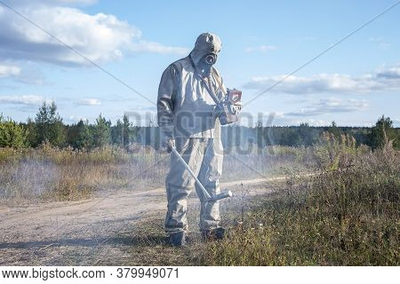 A Soldier In A Chemical Protection Suit Checks The Radioactive Territory With A Dosimeter Against Th
