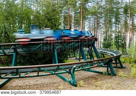 Ride Roller Coaster In Motion In Amusement Park At Summer Day