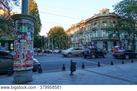 Odessa, Ukraine - August 4, 2020: Preobrazhenskaya street near the Cathedral square and city Park, green trees and people, road with car traffic