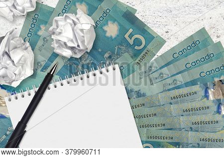 5 Canadian Dollars Bills And Balls Of Crumpled Paper With Blank Notepad. Bad Ideas Or Less Of Inspir