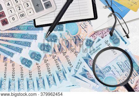 50 Sri Lankan Rupees Bills And Calculator With Glasses And Pen. Tax Payment Season Concept Or Invest