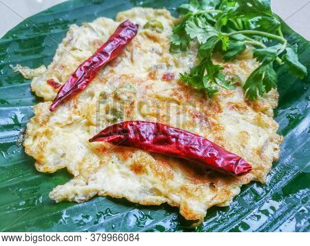 Omelette With Coriander Leaves And Red Chillies In A Banana Leaf.the Banana Leaf Has Green Color And