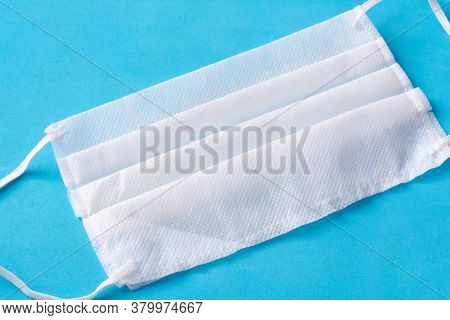 Medical Mask Or Surgical Earloop Face Mask On Porous Blue Background. Healthcare And Medical. Concep