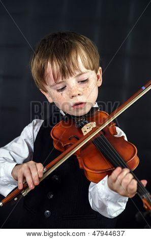 Freckled vermelho-cabelo menino tocando violino.