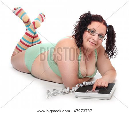 Gorda com uma máquina de pesagem. 