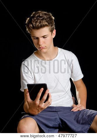 Ragazzo seduto con Ebook Reader o Tablet In mano