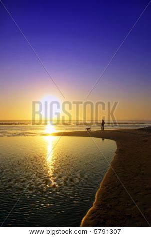 Silhuetter i stranden ved solnedgang.