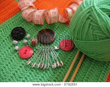 Needle, buttons and clew of wool